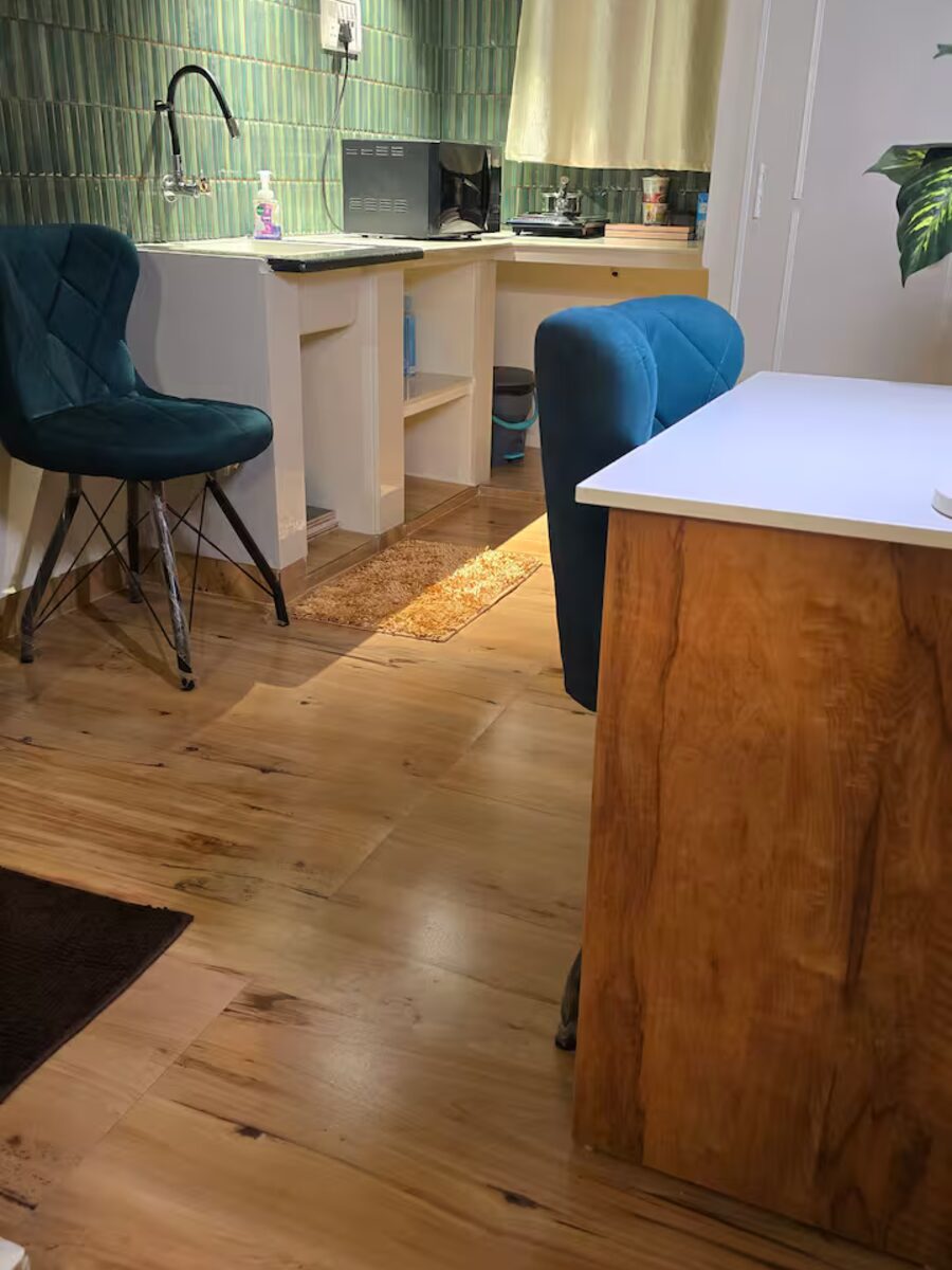 Small dining table with teal chairs by the kitchen