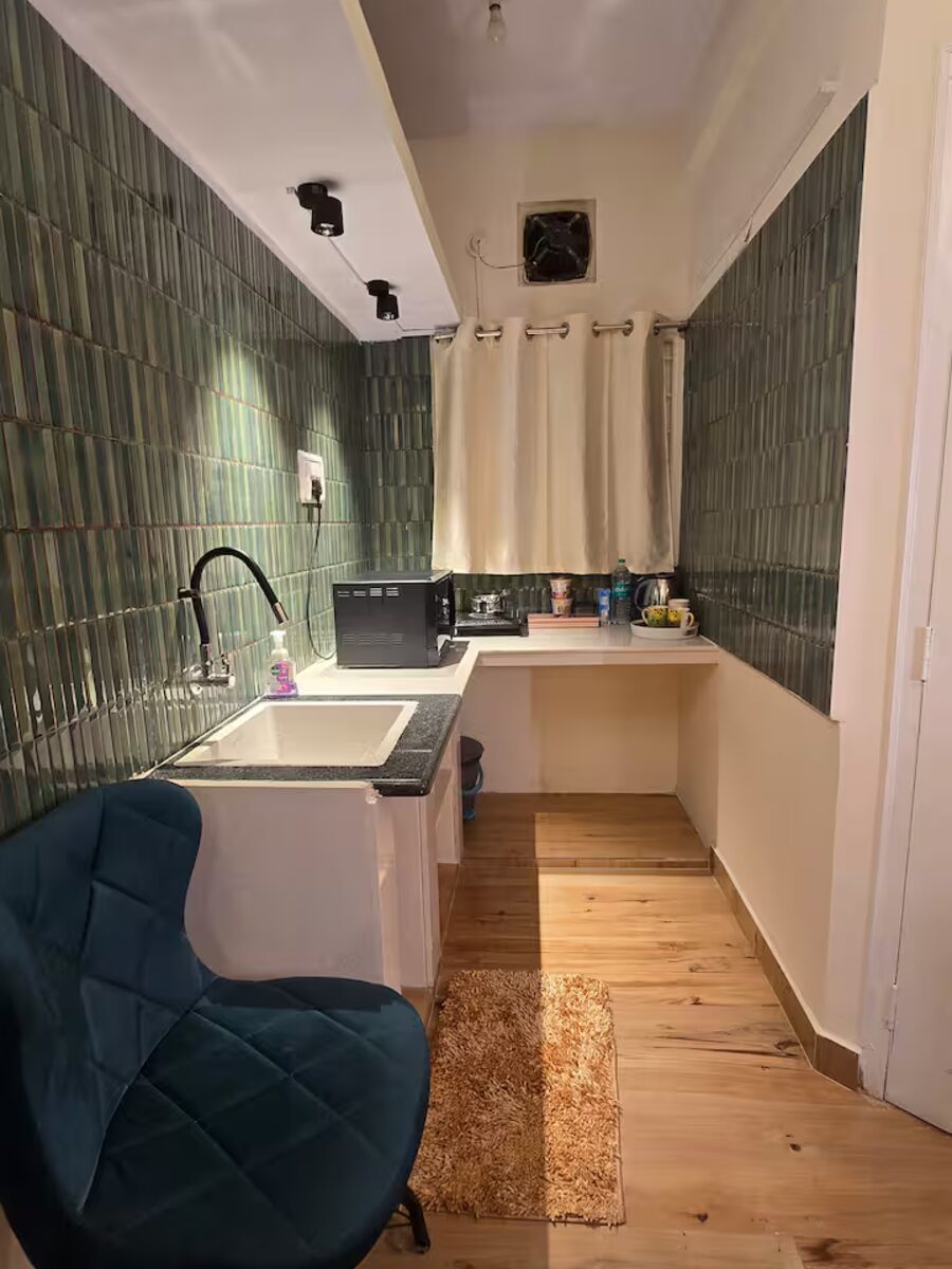Kitchen sink and counter along the green tiled wall