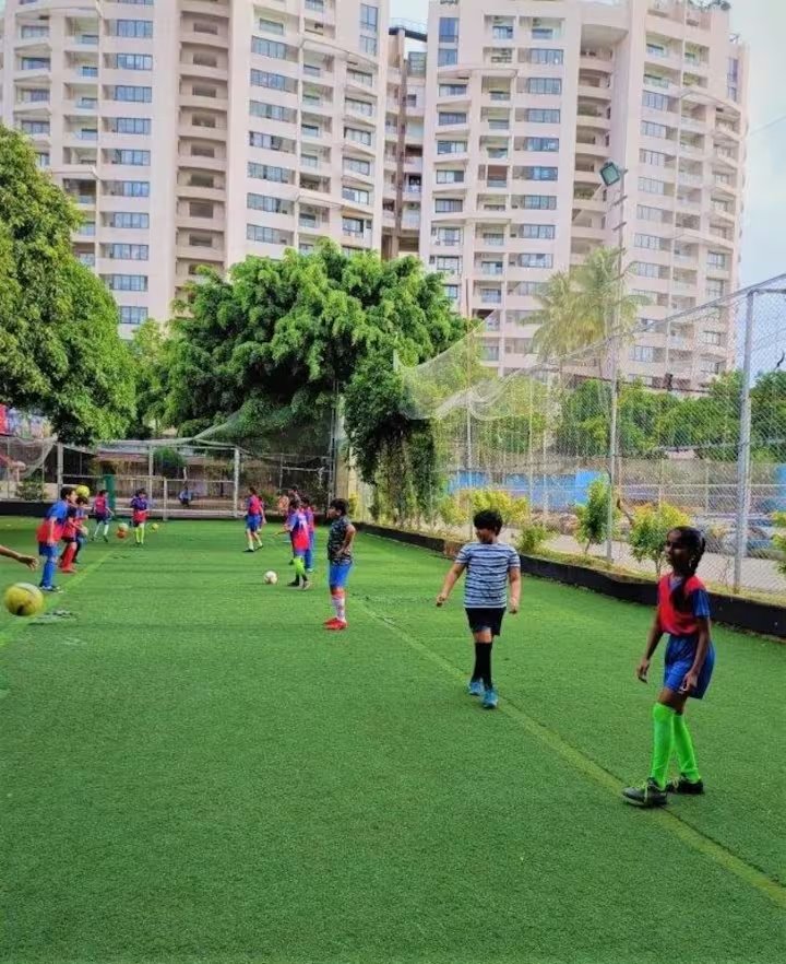Astro-turf football pitch by day with the city skyline behind