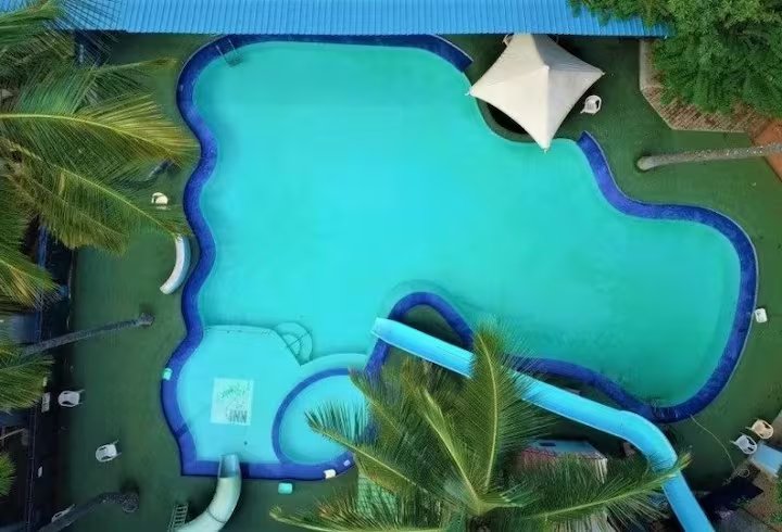Freeform swimming pool with a waterslide at Patels Inn Club & Resort
